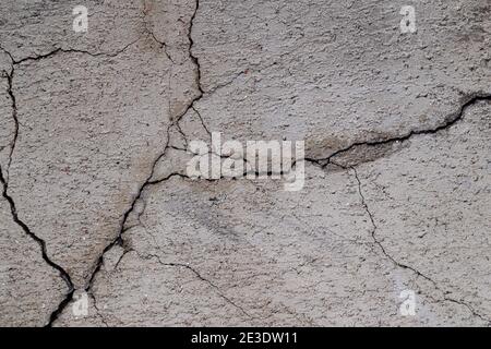Close-up of cracked and weathered cement wall, front view. High resolution full frame textured background. Stock Photo