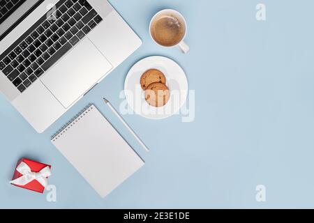 flat lay notebook, coffee, cookies, notepad, pencil and red box on blue.  Stock Photo