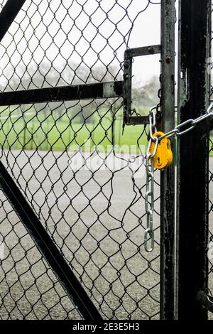 Playing courts, tennis and basketball, locked with yellow padlock and chain during the covid19 lockdown, London. Stock Photo