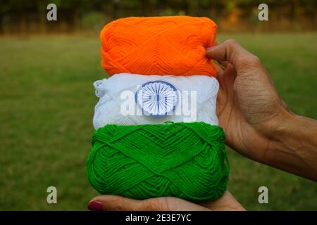 Indian flag tricolor tiranga saffron, white and green embroidery threads. Female palms holding embroidered thread as concept for Indian republic day c Stock Photo