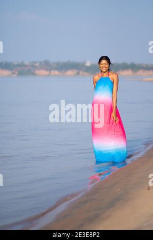 portrait of a happy beautiful african woman standing on a beach with a smile on her face Stock Photo