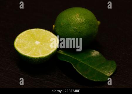 green lime and leaf isolated on a black background Stock Photo