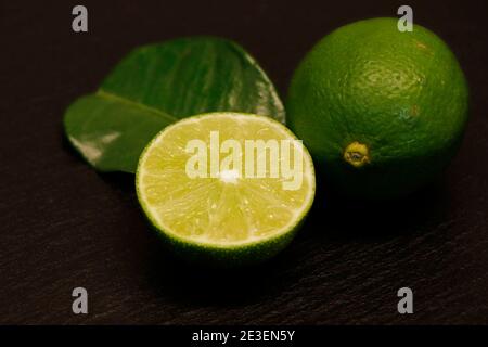 half and whole lime isolated on a black background Stock Photo