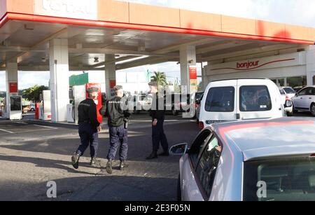 Motorists queue up as they wait to fill up their tank in a gas station in presence of policemen in Fort-de-France, Martinique, France on february 11, 2009 as the general strike caused a large shortage of all products. People protest in the capital of France's Caribbean island of Martinique, against the high cost of living, for better pay and employment. The French government named two mediators to help resolve the strikes, which paralysed Martinique and Guadeloupe, another French Caribbean overseas department since more than 20 days. Photo by Patrice Coppee/ABACAPRESS.COM Stock Photo