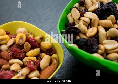 Some peanuts, raisins and nuts in a pot on a dark wooden table Stock Photo