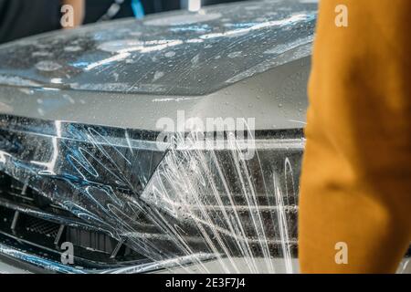 Transparent Paint Protection Film or anti-gravel protection coating wrapped on car hood. Car detailing. Stock Photo