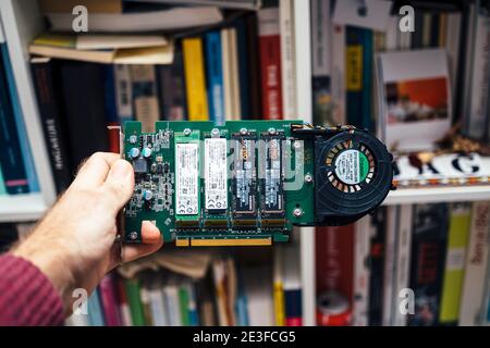 Paris, Frnace - 2019: Male hand holding new Dell Ultra Speed Drive Quad NVMe M2 Disk with multiple NVME disk from Samsung and SK Hynix inside Stock Photo