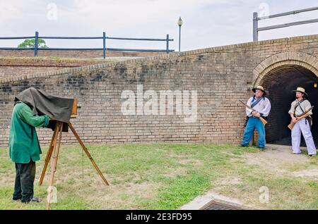 A photographer uses an antique view camera to photograph Civil War reenactors at Fort Gaines during a reenactment of the 150th Battle of Mobile Bay. Stock Photo