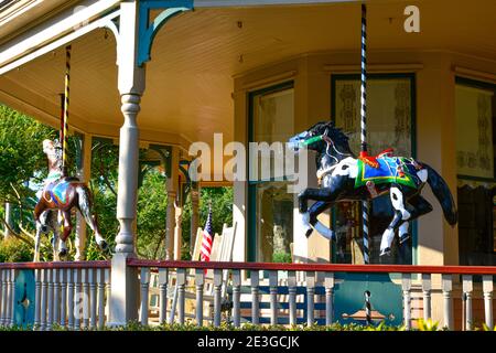Close up of  an antique carousel horse displayed on the front porch of the  Victorian Queen Anne style Bailey House in Fernandina Beach, FL on Amelia