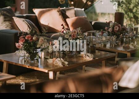 wooden table with personalized glasses, candles and flowers. Decoration for social events. Stock Photo