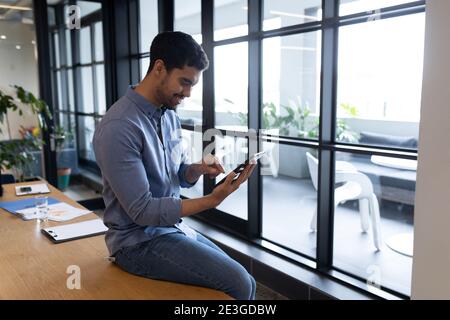 Mixed race businessman working in creative office Stock Photo