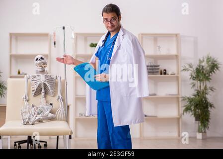 Young doctor suggesting pills to skeleton patient Stock Photo