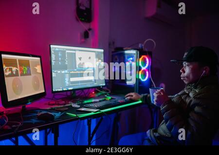 Editor man video editing and color list grading and enjoying with coffee in the house studio this is lifestyles of freelancer Stock Photo