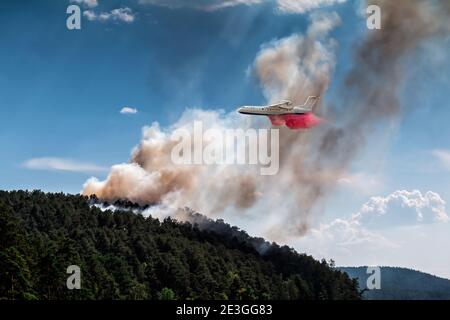 Big amphibious fire aircraft drops water on forest fire Stock Photo