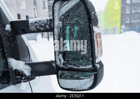 Snow in the rearview mirror of the car, drops on the glass. High quality photo Stock Photo