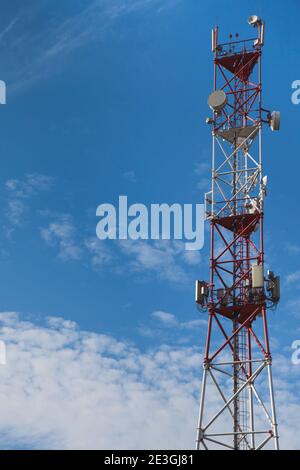 4G 5G cellular repeaters against a blue sky. Mobile phone Telecommunication Radio antenna Tower Stock Photo