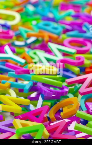 Heap of colorful rainbow alphabetic plastic character letters background, literature, education, know-how or writing concept, 3D illustration, selecti Stock Photo