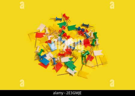 collection of different pushpins on a yellow surface Stock Photo