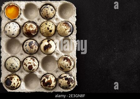 Quail eggs in the cardboard packing on the black table Stock Photo