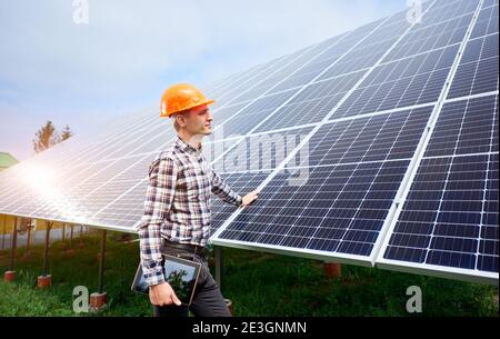 A worker stands near solar panels at the photovoltaic station Huadian ...