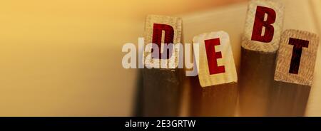 DEBT word made with wooden blocks. Liability unprofitable business or personal loss concept. Stock Photo