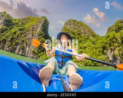Mom, dad and son travelers rowing on a kayak in Halong Bay. Vietnam. Travel to Asia, happiness emotion, summer holiday concept. Traveling with Stock Photo