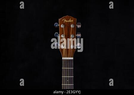 Fender acoustic guitar head with chrome tuning pegs and fretboard on isolated black background Stock Photo