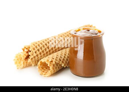 Wafer rolls and a jar of condensed milk isolated on white, sweet wafer rolls with condensed milk for a dessert design Stock Photo