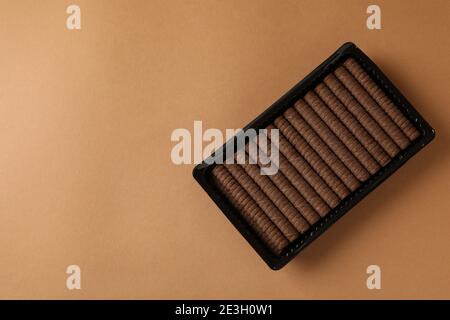 Plastic box with chocolate wafer rolls on brown background Stock Photo
