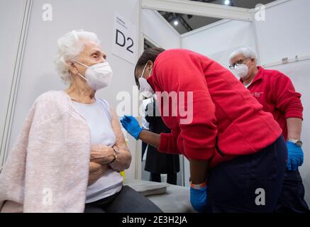 Frankfurt, Germany. 19th Jan, 2021. 19 January 2021, Hessen, Frankfurt/Main: A doctor vaccinates 90-year-old Odores H. (l) against the novel coronavirus in the Festhalle in Frankfurt. The state of Hesse operates one of its vaccination centres where thousands of people usually gather at concerts and trade fairs. On the first day of regular operation, around 500 people are to be vaccinated against Corona here. Photo: Boris Roessler/dpa Pool/dpa Credit: dpa picture alliance/Alamy Live News Stock Photo