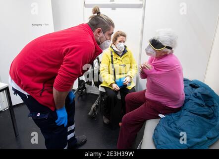 Frankfurt, Germany. 19th Jan, 2021. 19 January 2021, Hessen, Frankfurt/Main: A paramedic (l) informs 91-year-old Gisela F. about the procedure of the upcoming vaccination against the novel coronavirus. In between sits the woman's daughter, who accompanied her to the vaccination appointment. Where otherwise thousands of people gather at concerts and fairs, the state of Hesse operates one of its vaccination centers. On the first day of regular operation, around 500 people are to be vaccinated against Corona here. Photo: Boris Roessler/dpa Pool/dpa Credit: dpa picture alliance/Alamy Live News Stock Photo