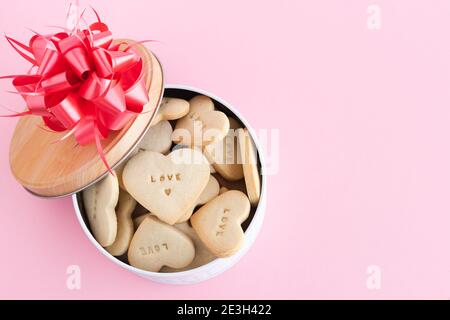Box with heart-shaped cookies with decorations on a pink background. Copy space. Stock Photo