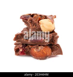 Chocolate pieces stack with nuts and berries, isolated on white background. Close up. Stock Photo