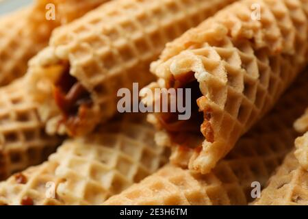 Tasty wafer rolls with condensed milk, close up Stock Photo