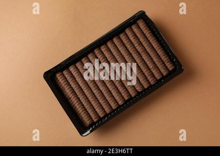Plastic box with chocolate wafer rolls on brown background Stock Photo