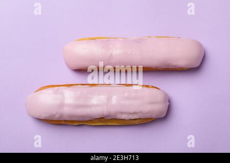 Delicious eclairs with custard on violet background Stock Photo