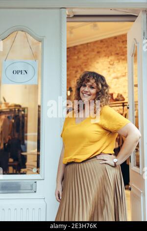 Clothing shop owner looking at camera and smiling. Successful female small business owner. Stock Photo