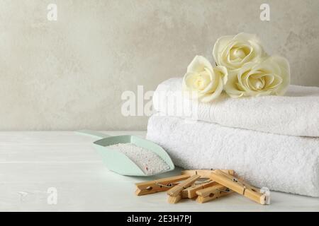 Scoop with powder, roses, clothespins and towels on white wooden table Stock Photo
