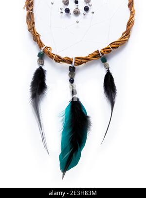 Part of a Dreamcatcher made of willow branches and green, black feathers, placed vertical on a pure white background. Stock Photo