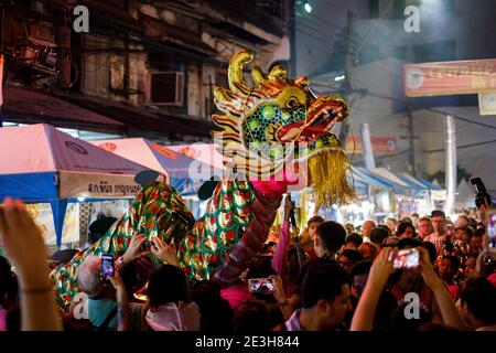 A crowd attends a dragon dance during Lunar New Year festival in Chinatown, Bangkok, Thailand. Stock Photo