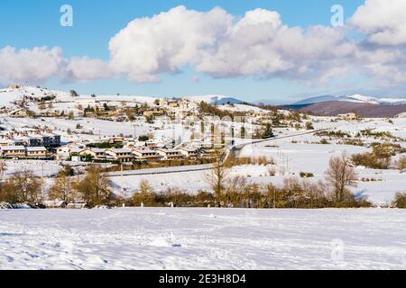 beautiful landscape where you can see a snowy village with a very blue sky and some white clouds and you can see mountains in the distance Stock Photo