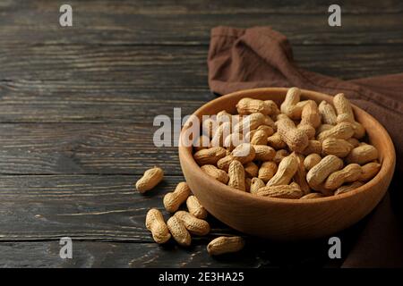 Napkin and bowl with peanut on wooden background Stock Photo