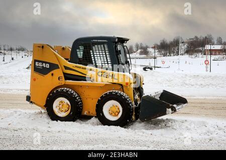 Yellow Gehl 6640 skid steer loader for removing snow in city parked at the side of a seaside street. Helsinki, Finland. January 18, 2021. Stock Photo
