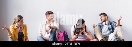 Multiethnic students talking while waiting exam in hall, banner Stock Photo