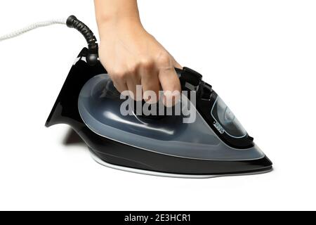 Female hand holding iron isolated on white background Stock Photo