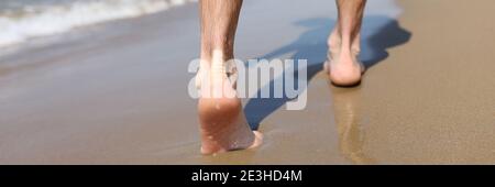 Male feet walking on sand at beach closeup Stock Photo