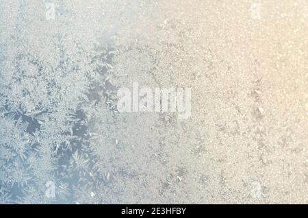 Light blue frosty patterns on the glass as a background, selective focus. Stock Photo