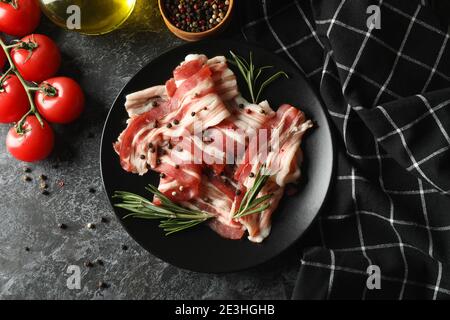 Concept of tasty snack with plate of bacon on black smokey background Stock Photo