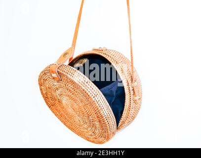 Opened round cross body rattan Ata bag with a leather strap and black lining Stock Photo