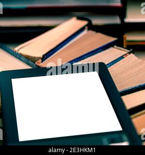 An e-book with a white screen and a place for text is on a shelf with old books Stock Photo
